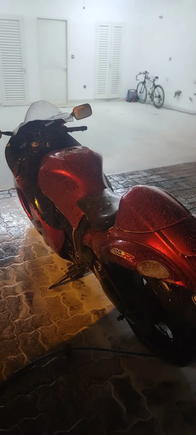 A red sports motorbike covered in foam in a garage