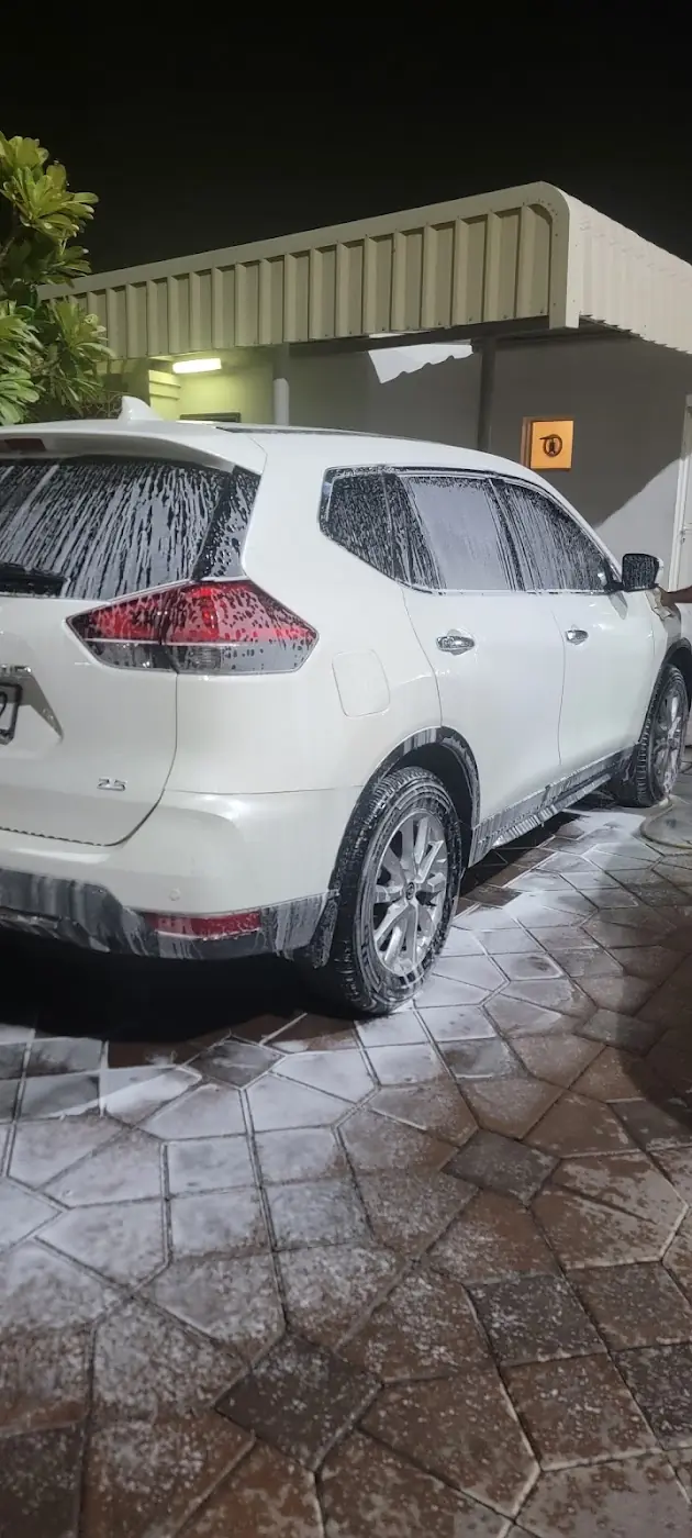 A white SUV covered in foam at night